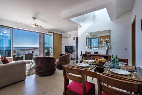 a living room with a table and chairs and a couch at Fuseta Apartments - Bela Vista & Vista Mar - Penthouses in Fuzeta