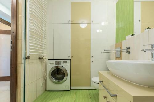 Un baño con lavadora y lavabo. en Prestige II, en Zakopane