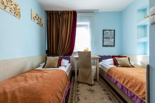 Una habitación con dos camas y una mesa y una ventana. en Prestige II, en Zakopane