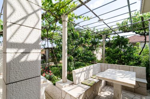 un patio con una mesa y una pérgola en Katarina Rooms, en Dubrovnik