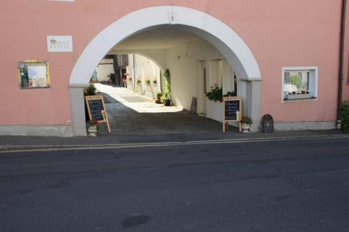 an entrance to a pink building with an archway at Hotel Gasthof Zum weissen Lamm in Hohenberg an der Eger