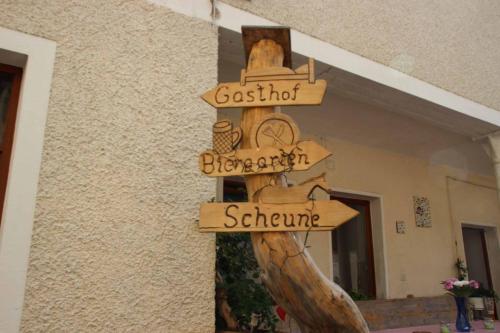 a wooden directional sign in front of a building at Hotel Gasthof Zum weissen Lamm in Hohenberg an der Eger