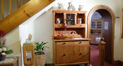a room with a wooden cabinet with vases on it at Hotel Gasthof Zum weissen Lamm in Hohenberg an der Eger