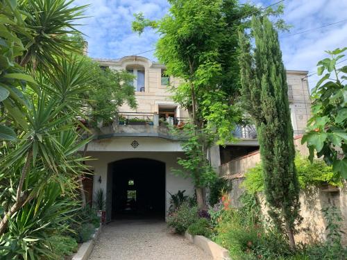 Casa grande con patio con árboles y plantas en Chambre d'Hôtes Lo Componaïro, en Pouzols