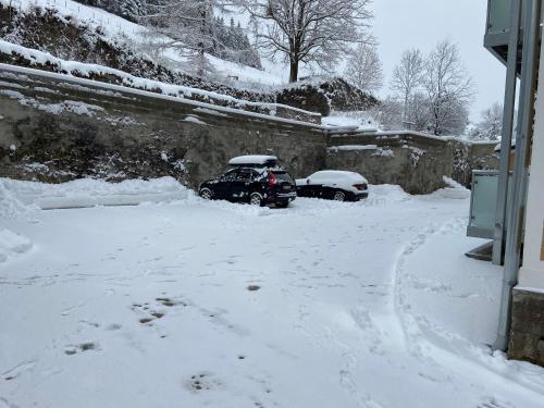 two cars parked in a snow covered driveway at Vordernberg Štýrské Alpy in Vordernberg