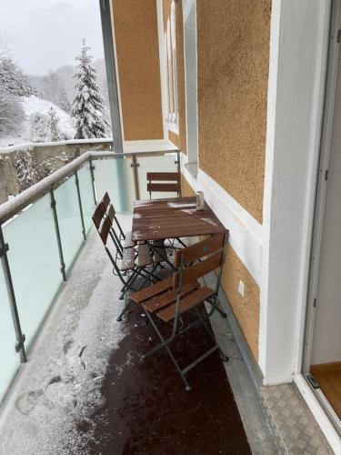 a table and chairs sitting on a balcony with snow at Vordernberg Štýrské Alpy in Vordernberg