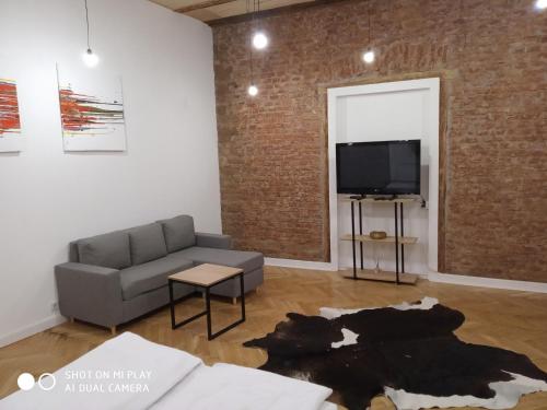 a living room with a couch and a tv at Gogol 14 Апартаменти в історичному центрі міста in Uzhhorod