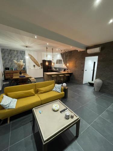 un salon avec un canapé jaune et une table dans l'établissement Appart 110m2 terrasse climatisé quartier médiéval, à Clermont-Ferrand
