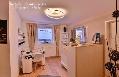 a room with a desk and a table with a computer at Ferienwohnung Am Wäldchen in Erfurt