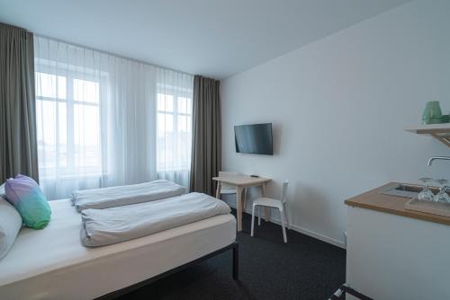 a hotel room with two beds and a table at BIG MAMA Leipzig in Leipzig