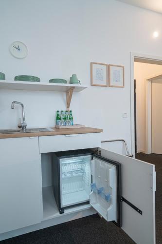an open refrigerator under a counter in a kitchen at BIG MAMA Leipzig in Leipzig