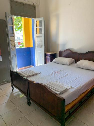 a large bed in a room with a window at Hotel América in Recife