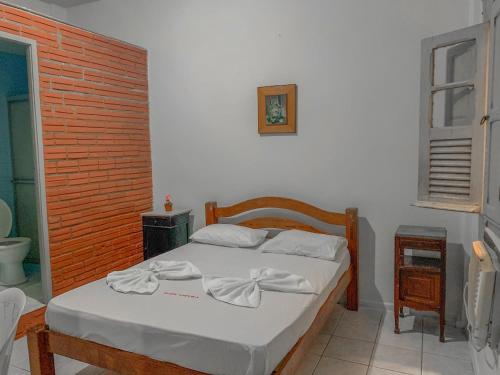 a bedroom with a bed with towels on it at Hotel América in Recife