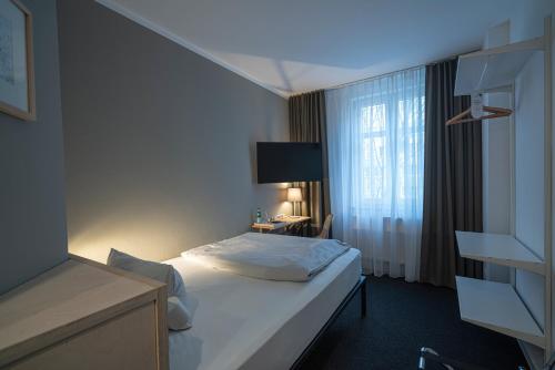 a hotel room with a bed and a window at BIG MAMA Leipzig in Leipzig