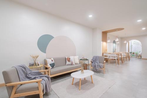 a living room with a couch and chairs and a table at COROOM BKK in Bangkok