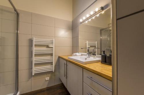 a bathroom with a sink and a mirror at My Hotel Peyrou - Premiere conciergerie in Montpellier