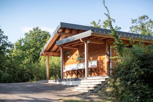 a wooden house with a black roof at Huttopia Royat in Royat