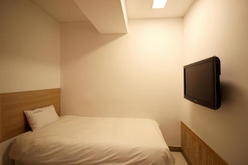 a bedroom with a bed and a tv on the wall at Hotel Irene City in Seoul