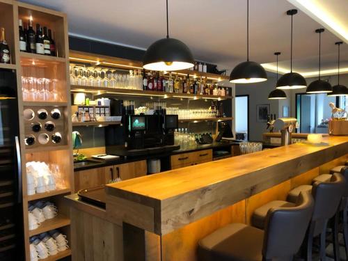 a bar with a wooden counter and some chairs at Landhaus Bruckmann in Saerbeck