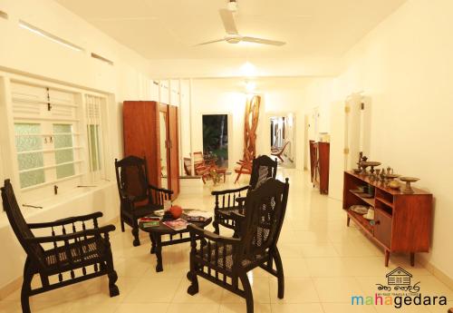 Mahagedara Dickwella في ديكويلا تين: غرفة معيشة مع كراسي وطاولة وحوض استحمام