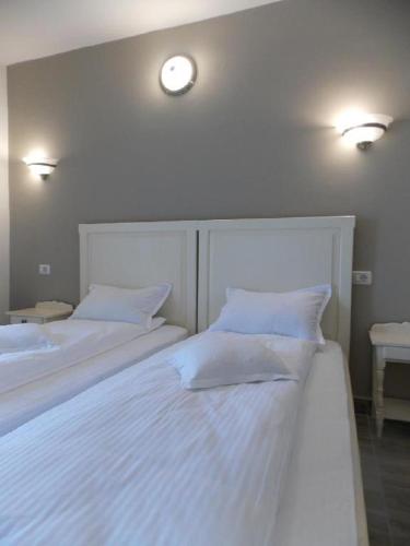 two beds in a bedroom with two lights on the wall at Pensiune Xe-Mar in Arad