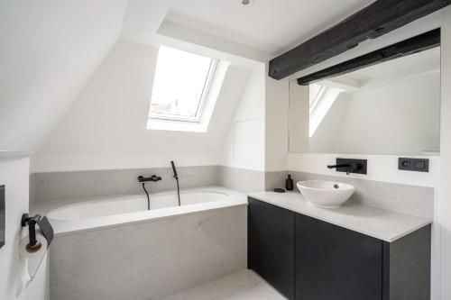 a white bathroom with a tub and a sink at Smartflats - Grand-Place II in Brussels