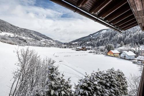 a view of a snow covered field from a house at Hotel OTP Birkenhof in Bad Kleinkirchheim