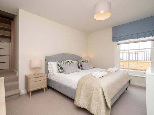 ein weißes Schlafzimmer mit einem Bett und einem Fenster in der Unterkunft Pass The Keys Quiet 1 bed central apartment with parking in Bath