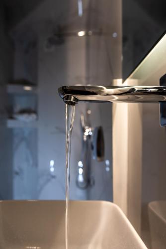 a stream of water coming out of a sink at Macrame Luxury Suites in Tríkala
