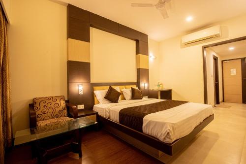 a hotel room with a bed and a chair at Sri Krishna Palace in Hosūr