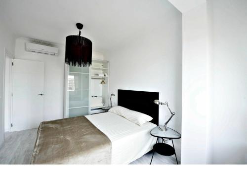 バルセロナにあるNiM Sagrada Familia 2の白いベッドルーム(大型ベッド1台、ランプ付)