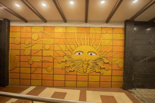 a wall with a painting of a sun on it at Sri Krishna Palace in Hosūr