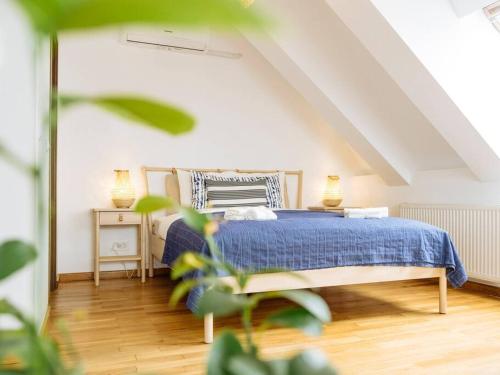 a bedroom with a blue bed in a attic at Vivando - Cosy Double Studio B + parking in Bucharest