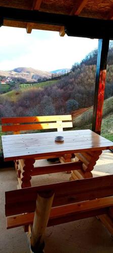 a wooden table in front of a window with a view at Etno kuća Ostrvica in Varnice