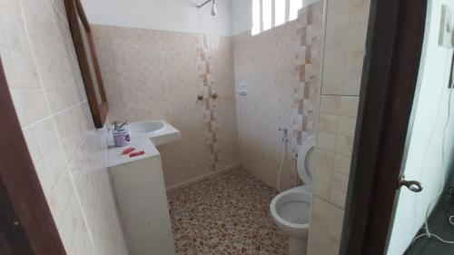 uma casa de banho com um lavatório e um WC em Shela Bahari em Shela