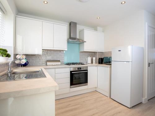 a kitchen with white cabinets and a white refrigerator at 2 Bedroom Home Near the Heart of Ludlow - Pass the Keys in Ludlow