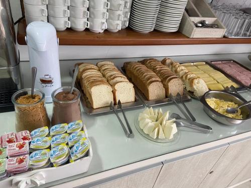 a buffet with sandwiches and other food on a counter at Xangri-La Praia Hotel in Xangri-lá