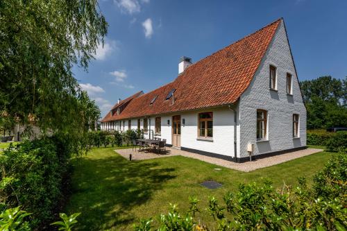 a large white building with a red roof at Loweide Lodges & Holiday Homes near Bruges in Oostkamp