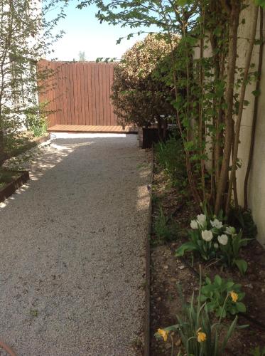 a driveway with a fence and some flowers at Isäntä in La Ferté-Saint-Aubin