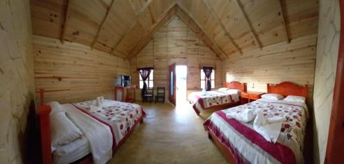 pokój z 2 łóżkami w drewnianym domku w obiekcie Cabañas camino real w mieście Santiago