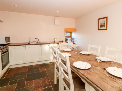 a kitchen and dining room with a wooden table and chairs at Blackburn Cottage Barn in Hamsterley