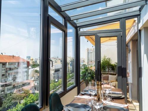 a dining room with windows and a table with wine glasses at Heart 10 Cupole in Bucharest