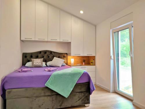 a bedroom with a large bed with purple sheets at Luxury Sunrise Jacuzzi Apts, 50 m from the beach in Kali