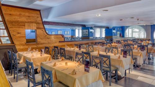 a restaurant with tables and chairs in a room at Playacálida in Almuñécar