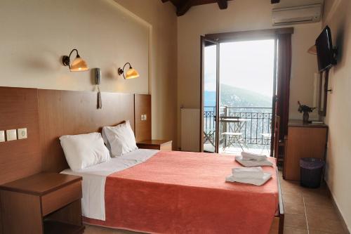 a hotel room with a bed and a balcony at Castri Hotel in Delfoi