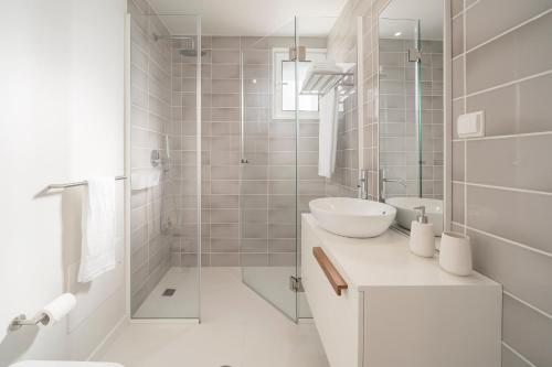 Un baño blanco con lavabo y ducha. en Lido I by An Island Apart, en Funchal