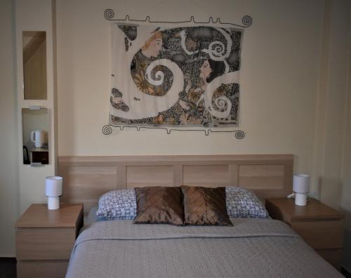 克萊佩達的住宿－Guest House Gero Vėjo Namai，卧室配有一张床,墙上挂有绘画作品