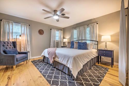 1 dormitorio con 1 cama con ventilador de techo y silla en Howdy Haus Pool and Hot Tub and Outdoor Space, en Fredericksburg