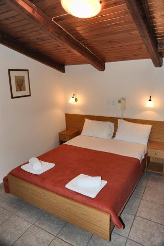 a bedroom with a bed with two towels on it at Castri Hotel in Delfoi