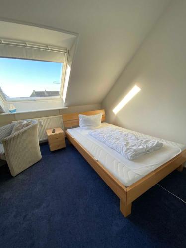a bedroom with a large bed with a window at Haus Strandlaeufer App 7 in List